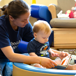 teacher reading a book to a baby