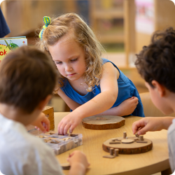 three children playing with puzzles at preschool