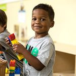 junior k boy playing with legos